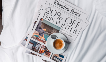 'up to 20% off' newspaper and coffee on bed